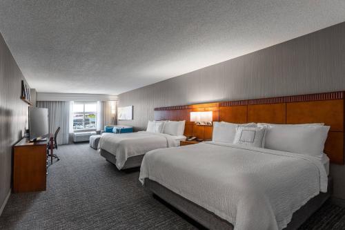 a hotel room with two beds and a television at Courtyard Columbus Easton in Columbus