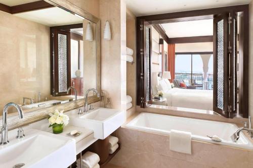 a bathroom with two sinks and a large mirror at The Ritz-Carlton Abu Dhabi, Grand Canal in Abu Dhabi