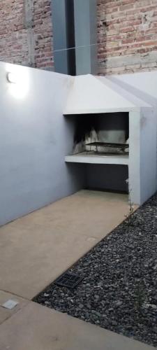 un gato tirado en un estante bajo un banco blanco en TEMPORARIOS ROCA en General Roca