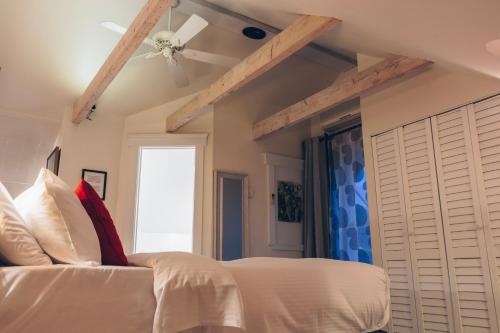 a bedroom with a white bed and a ceiling fan at Auberge aux Deux Lions in Quebec City