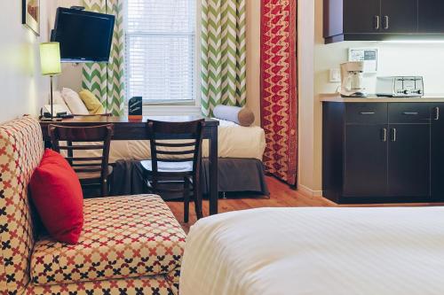 a hotel room with a bed and a table and chairs at Auberge aux Deux Lions in Quebec City