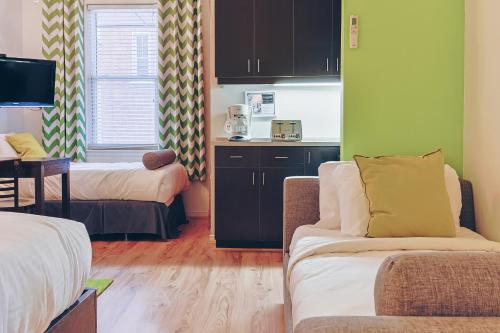 a small living room with a couch and a kitchen at Auberge aux Deux Lions in Quebec City