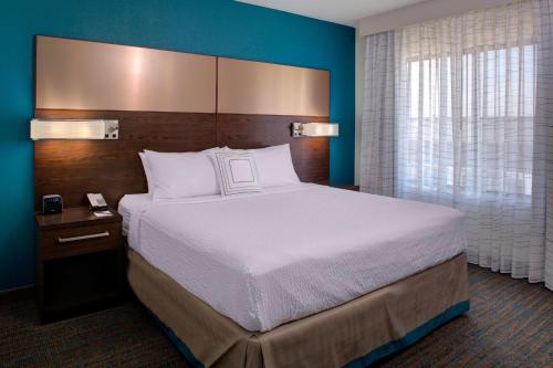 um quarto com uma cama grande e uma parede azul em Residence Inn by Marriott Dallas Allen/Fairview em Fairview