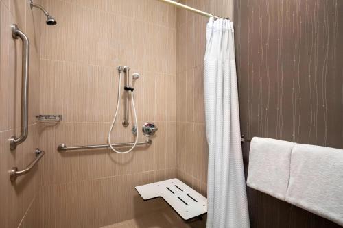 a bathroom with a shower with a toilet in it at Courtyard by Marriott Champaign in Champaign