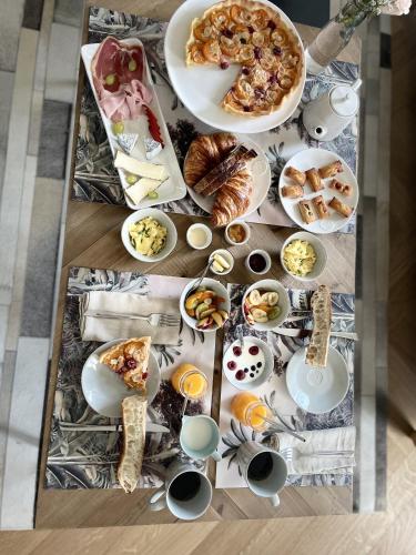une table avec différentes assiettes de nourriture dans l'établissement Château de Neyran chambre d'hôtes & Spa, à Soulac-sur-Mer