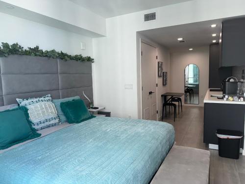 a bedroom with a large bed and a kitchen at Comfortable Studio with King Bed and Queen Sofa-bed in Miami