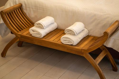 - une chaise en bois avec des serviettes dans la salle de bains dans l'établissement Genesis Grande Acropolis Hill Villa, à Athènes