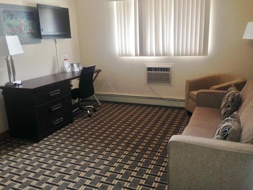 a hotel room with a desk and a couch and a chair at Super 8 by Wyndham Valemount in Valemount