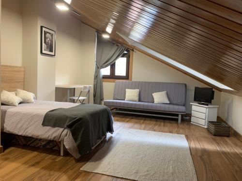 a bedroom with a bed and a couch at VILLA RAICES. Agradable casa con piscina in Baiona