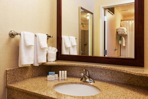 a bathroom with a sink and a mirror and towels at SpringHill Suites Charlotte Lake Norman/Mooresville in Mooresville