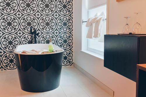 a bathroom with a bath tub and a wall at Auberge aux Deux Lions in Quebec City
