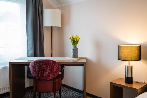 a room with a desk with a chair and two lamps at Point Hotel Apartments and Rooms in Dresden