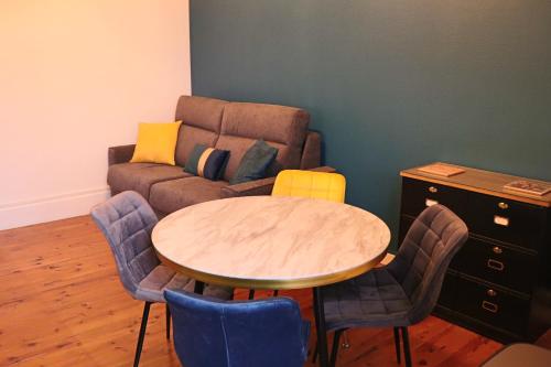 un salon avec une table et un canapé dans l'établissement Appartement 2/4 pers Vacance-Cure cosy et ensoleillé, à La Bourboule