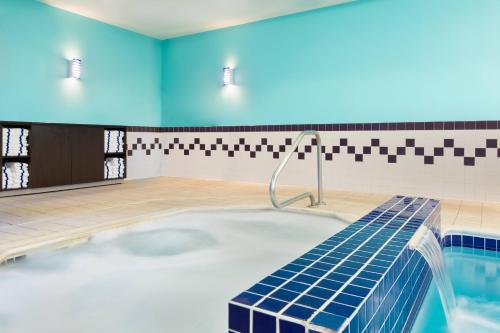 a swimming pool with a hot tub in a room with blue walls at SpringHill Suites by Marriott Cleveland Solon in Solon