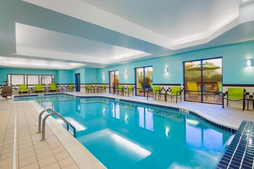 SolonにあるSpringHill Suites by Marriott Cleveland Solonのテーブルと椅子付きのホテルルームのプールを利用できます。