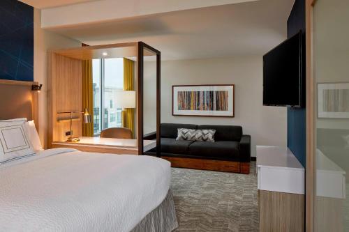 ナッシュビルにあるSpringHill Suites by Marriott Nashville Downtown/Convention Centerのベッドとソファ付きのホテルルーム