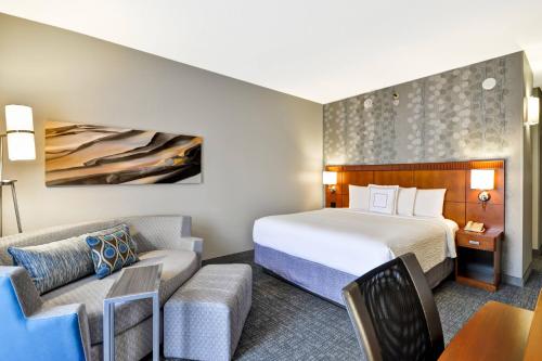 um quarto de hotel com uma cama e um sofá em Courtyard Dallas Medical Market Center em Dallas