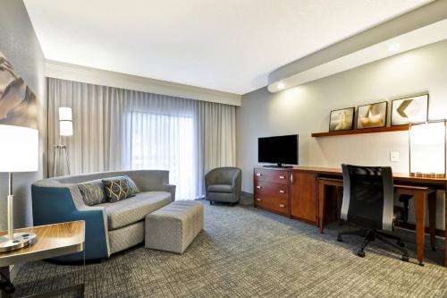 a living room with a couch and a desk at Courtyard Dallas Medical Market Center in Dallas