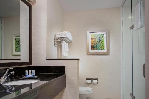 a bathroom with a sink and a toilet and a mirror at Fairfield by Marriott Inn & Suites Aberdeen in Aberdeen