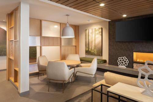 a dining room with a table and chairs and a fireplace at Fairfield Inn & Suites by Marriott Fresno North/Shaw Avenue in Fresno