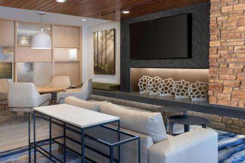 a waiting room with a tv on a brick wall at Fairfield by Marriott Inn & Suites Aberdeen in Aberdeen