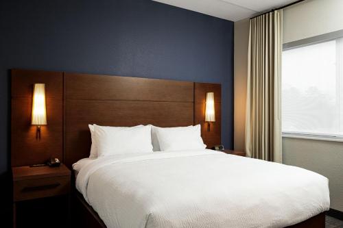 ein Schlafzimmer mit einem großen Bett und einem großen Fenster in der Unterkunft Residence Inn by Marriott Jackson Airport, Pearl in Pearl