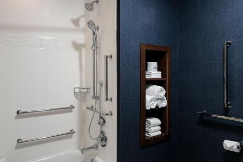 een badkamer met een douche, een toilet en handdoeken bij Residence Inn by Marriott Jackson Airport, Pearl in Pearl