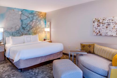 a hotel room with a bed and a couch at Courtyard by Marriott Ocala in Ocala