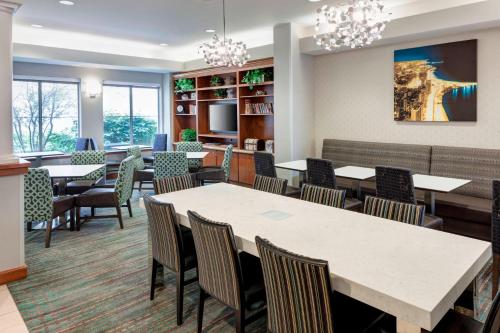 a dining room with tables and chairs and chandeliers at Residence Inn by Marriott Chicago Lake Forest/Mettawa in Mettawa