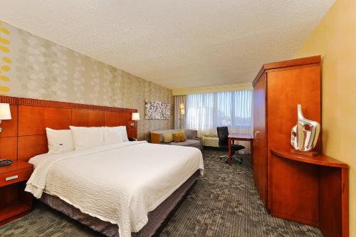 a hotel room with a bed and a desk at Courtyard by Marriott Denver Cherry Creek in Denver