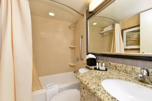 a bathroom with a sink and a tub and a mirror at Courtyard by Marriott Denver Cherry Creek in Denver