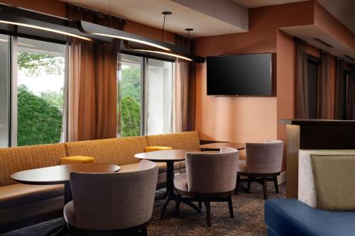 ナッシュビルにあるSpringHill Suites Nashville MetroCenterのテーブルと椅子とテレビのある待合室