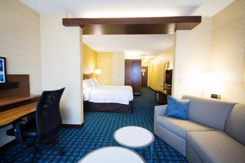 Habitación de hotel con sofá y cama en Fairfield Inn & Suites by Marriott Denver Northeast/Brighton en Brighton
