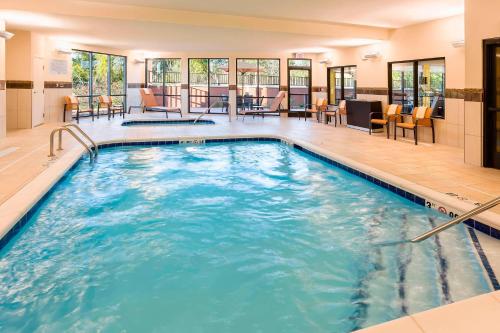 een groot zwembad met blauw water in een hotelkamer bij Courtyard by Marriott Kalamazoo Portage in Portage