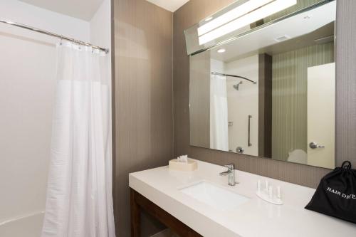 a bathroom with a sink and a mirror at Courtyard by Marriott Fayetteville Fort Bragg/Spring Lake in Spring Lake