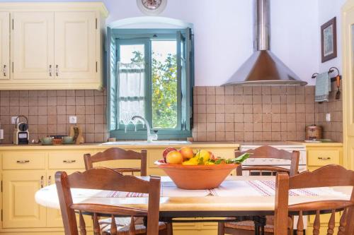 a kitchen with a table with a bowl of fruit on it at Villa Matakia in Áno Potamiá