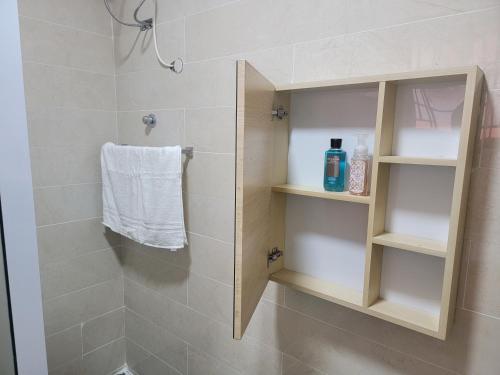 a bathroom with a shower with a white towel at VaQ Apartments in Spintex