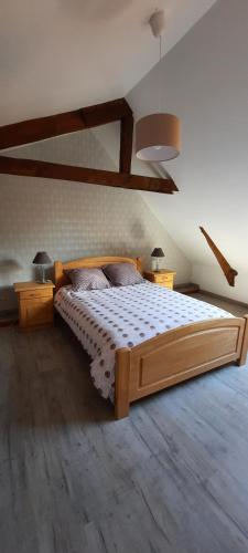 une chambre avec un grand lit en bois dans une pièce dans l'établissement Gîte à la ferme le vivier, à Lottinghen