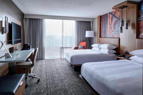 a hotel room with two beds and a desk at Auburn Hills Marriott Pontiac in Pontiac