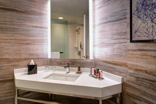 y baño con lavabo blanco y espejo. en Auburn Hills Marriott Pontiac, en Pontiac