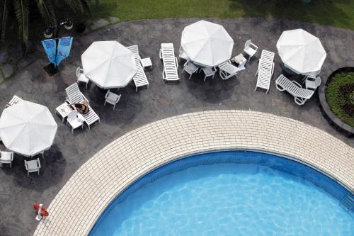 an overhead view of a swimming pool with tables and umbrellas at Seogwipo KAL Hotel in Seogwipo