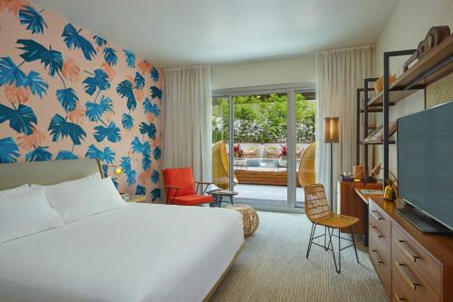 a hotel room with a bed and a television at The Laylow, Autograph Collection in Honolulu