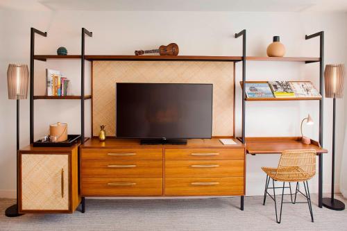 a entertainment center with a television on top of it at The Laylow, Autograph Collection in Honolulu