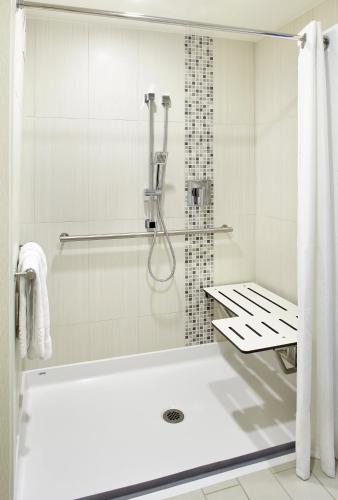 a white bathroom with a tub and a shower at Raleigh Marriott Crabtree Valley in Raleigh