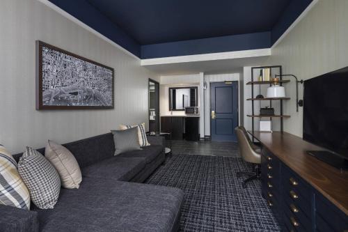 a living room with a couch and a flat screen tv at The Notary Hotel, Philadelphia, Autograph Collection by Marriott in Philadelphia