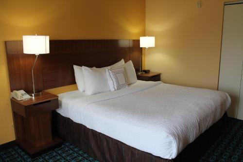 una camera d'albergo con un grande letto con due lampade di Fairfield by Marriott Frankfort a Frankfort