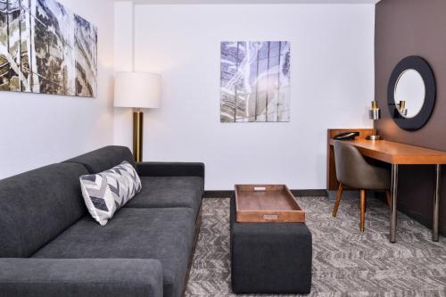 a living room with a couch and a desk at SpringHill Suites Fairfax Fair Oaks in Fairfax
