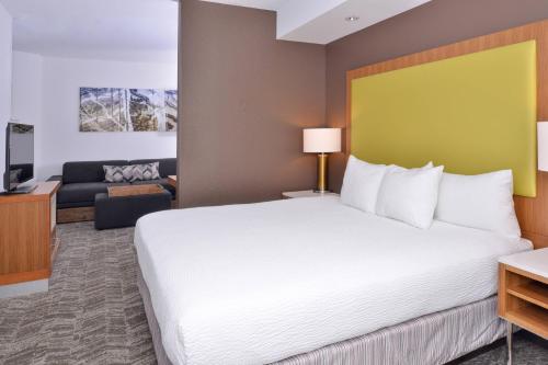 a hotel room with a bed and a couch at SpringHill Suites Fairfax Fair Oaks in Fairfax
