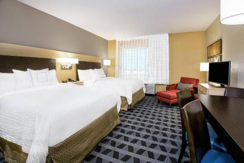 a hotel room with two beds and a television at TownePlace Suites by Marriott Corpus Christi Portland in Portland