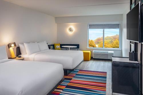 a hotel room with two beds and a window at Aloft Framingham in Framingham